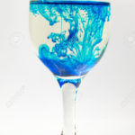 Glass full of water with ink color drop